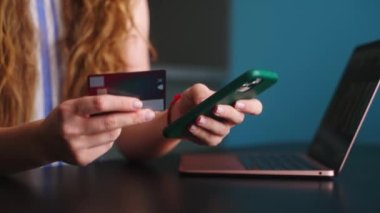 Mutlu kadına yakın çekim satın alma, ödeme Fintech uygulaması ile telefonda. Alıcı kız mobil bankacılık uygulaması kullanıyor, banka kartı ile online mağazada ödeme yapıyor. Düzenin sağlanması için kadın alkışı..