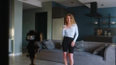 Sosyal medya platformunda beğeniler ve takipçiler için moda dans yarışmasının bayan video kaydı. Komik dans eden bir kadın, ev stüdyosundaki oturma odasında öyküler için performansını filme alıyor..