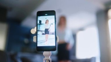 Sosyal medya platformunda beğeniler ve takipçiler için moda dans yarışması videosu kaydeden güzel bir kız. Komik dans eden bir kadın, bir stüdyoda akıllı telefon kamerasıyla kendi performansını filme alıyor..