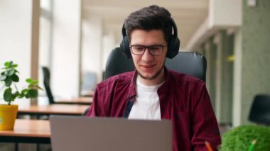 Geliştirici, kulaklıklı video editörü geniş bir iş yerinde dizüstü bilgisayarla tek başına müzik eşliğinde çalışıyor. Şık yaratıcı müzisyen yapımcı ofiste tek başına şarkı dinliyor. Çevrimiçi oyuncu oyun oynuyor.
