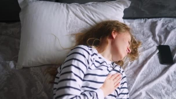 Καυκάσια Γυναίκα Που Υποφέρει Από Καρδιακό Πόνο Κάθεται Στο Κρεβάτι — Αρχείο Βίντεο