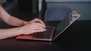 Kameralar kadın serbest çalışanların elleri etrafında kayıyor ve dizüstü bilgisayarda yavaş çekimde klavyeyle yazı yazıyorlar. Ofiste internetle çalışan iş kadını. Evden uzakta çalışan bir kız. Yavaş çekim takip çekimi..