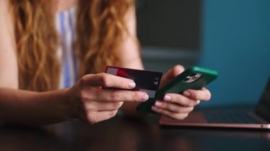 Mutlu kadına yakın çekim satın alma, ödeme Fintech uygulaması ile telefonda. Alıcı kız mobil bankacılık uygulaması kullanıyor, banka kartı ile online mağazada ödeme yapıyor. Düzenin sağlanması için kadın alkışı..