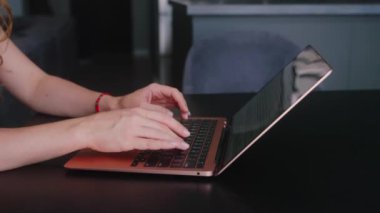 Kameralar kadın serbest çalışanların elleri etrafında kayıyor ve dizüstü bilgisayarda yavaş çekimde klavyeyle yazı yazıyorlar. Ofiste internetle çalışan iş kadını. Evden uzakta çalışan bir kız. Yavaş çekim takip çekimi..