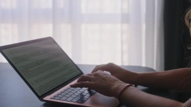 Kameralar kadın serbest çalışanların elleri etrafında kayıyor ve dizüstü bilgisayarda yavaş çekimde klavyeyle yazı yazıyorlar. Ofiste internetle çalışan iş kadını. Evden uzakta çalışan bir kız. Yavaş çekim takip çekimi..