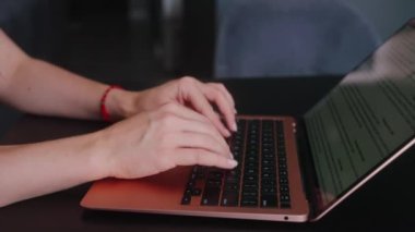 Kameralar kadın serbest çalışanların elleri etrafında kayıyor ve dizüstü bilgisayarda yavaş çekimde klavyeyle yazı yazıyorlar. Ofiste internetle çalışan iş kadını. Evden uzakta çalışan bir kız. Yavaş çekim takip çekimi..