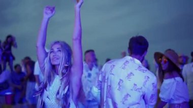 2020-07-25 - Henychensk, Ukraine. Spot Guide Kite Club - Wave Festival. Multi ethnic people in boho outfits dance enjoy open air music fest on sunset by sea. Stylish audience have fun on beach party.