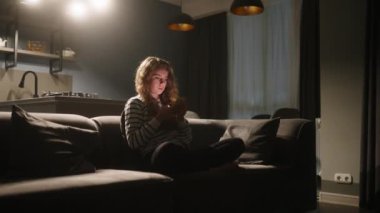 Akıllı telefonları kaydıran, internette sörf yapan gece şık oturma odasındaki kanepede oturan bir kadın. Mobil oyunlar oynayan ya da mağazadan alışveriş yapan bir kadın. Telefonu olan kız sosyal ağlarda sohbet etmekten hoşlanıyor.