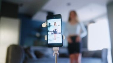 Kıvırcık kız sosyal medya platformunda beğeniler ve takipçiler için moda dans yarışması videosu kaydediyor. Komik dans eden bir kadın, bir stüdyoda akıllı telefon kamerasıyla kendi performansını filme alıyor..