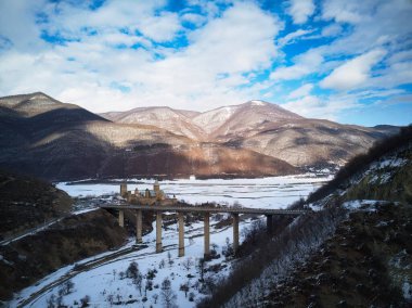 Gürcistan 'ın Aragvi Nehri' ndeki Ananuricastle kompleksi viyadük köprüsünün yanında. Kafkas dağlarında karlı kış manzarası.