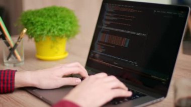 Serbest çalışanların ellerini dizüstü bilgisayarın klavyesinde daktilo koduyla kapat. Kamera geliştiricilerin etrafında slayt yapar parmaklar bilgisayar ekranına bir program kodu yazarlar. Çevrimiçi uygulama veritabanı üzerinde çalışan programcı.
