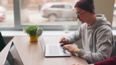 İki hippi iş arkadaşı geniş bir uzay ofisinde dizüstü bilgisayarlarla oturma projesini paylaşıyor. Geliştiriciler uygulama programı kodunu tartışıyor. Kodlayıcı ve yönetici yazılım mimarisine danışır.