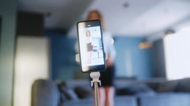 Blogcu kız sosyal medya platformunda popüler dans yarışmasının videosunu kaydediyor. Komik dans eden bir kadın, bir stüdyoda akıllı telefon kamerasıyla kendi performansını filme alıyor..