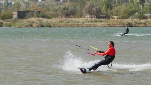 Kiteboarder骑在海湾里的风筝上自由式风筝在池塘上的训练 Kitesurfer喜欢骑马极端水上运动 — 图库视频影像