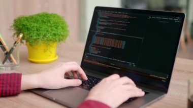 Serbest çalışanların ellerini dizüstü bilgisayarın klavyesinde daktilo koduyla kapat. Kamera geliştiricilerin etrafında slayt yapar parmaklar bilgisayar ekranında program kodunu yavaş çekimde yazar. Bir uygulama üzerinde çalışan programcı.