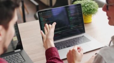 İki hippi iş arkadaşı geniş bir uzay ofisinde dizüstü bilgisayarlarla oturma projesini paylaşıyor. Geliştiriciler uygulama programı kodunu tartışıyor. Kodlayıcı ve yönetici yazılım mimarisine danışır.
