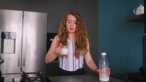 女性の飲み物は牛乳を期限切れにし キッチンに立って重度の胃の痛みに苦しんでいます 乳糖不耐性の女性は質の低い牛乳を試みる 消化器系疾患の女の子は腹の痛みを感じる — ストック動画