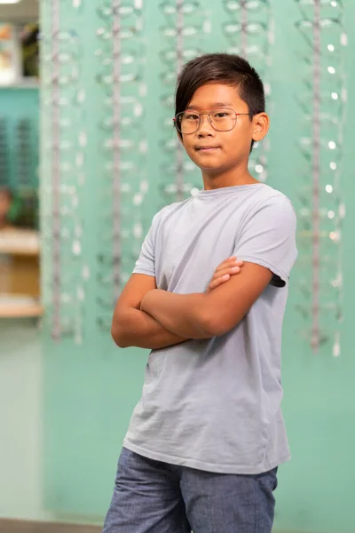 Азіатський хлопчик намагається на окулярах в оптичному магазині . — стокове фото
