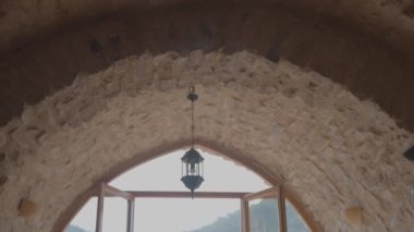 Büyük bir odada, pencerenin yanında İspanyol gitar çalan bir kadın.