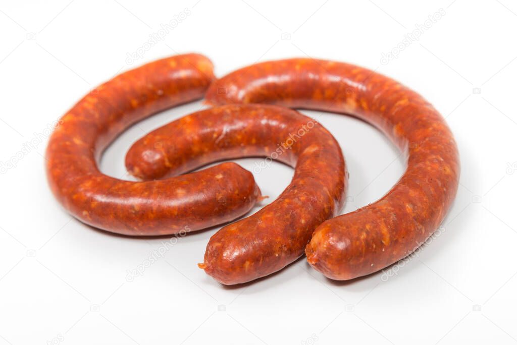 Three red chorizo crude sausages on a white background