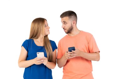 Beyaz arka planda genç bir çift akıllı telefona bakıyor..