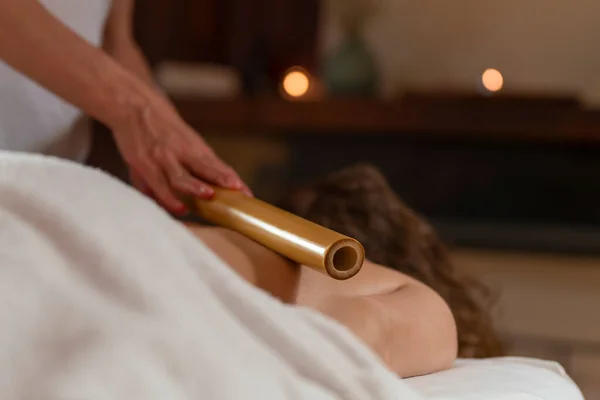 Mulher massagista realiza uma massagem com uma bambu cana para outra mulher — Fotografia de Stock