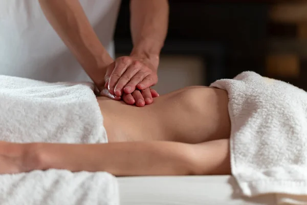 Uma massagista fazendo uma massagem de óleo para outra mulher no estômago — Fotografia de Stock