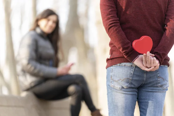 Man verrast zijn vriendin met een hartvormig geschenk — Stockfoto