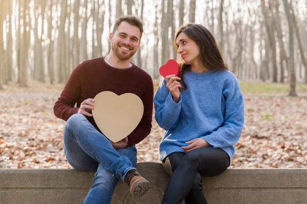 Młoda para świętująca Walentynki daje sobie prezent w parku — Zdjęcie stockowe
