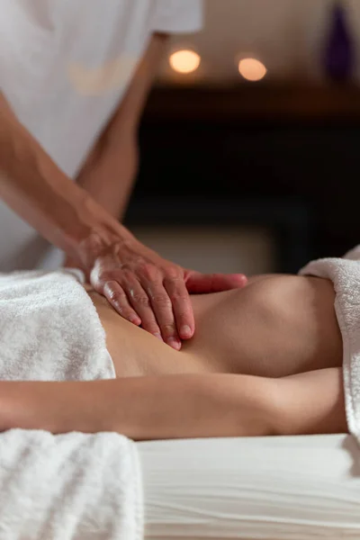 Uma massagista fazendo uma massagem de óleo para outra mulher no estômago — Fotografia de Stock