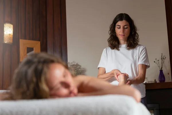 Uma fisioterapeuta mulher fazendo uma massagem para outra mulher — Fotografia de Stock