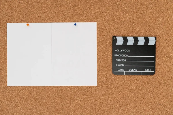 软木塞板背景图，带有电影剪贴板和两张空白的白纸 — 图库照片