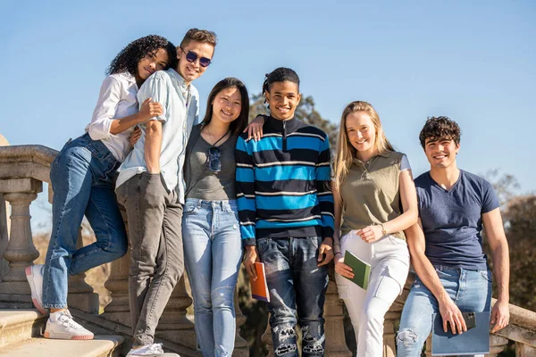 Bir grup genç çok ırklı öğrenci kameraya bakıyor.