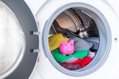 İçinde kumbara olan bir çamaşır makinesiyle elektrik tasarrufu kavramı