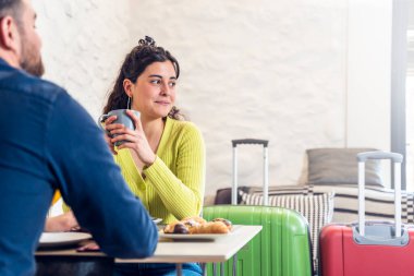 Turist kadın bir adamla otel restoranında kahvaltı yapıyor.