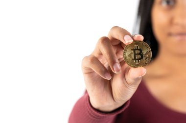 Kameraya fotokopi alanı olan beyaz arka planda bitcoin gösteren genç bir zenci kadın.