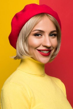 Sarı arka planda kırmızı birette giyen sarışın.