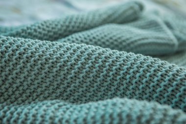 Rahat bir ekoseye basit desenler ördüm, arka planda bulanık mavi örgü dokular, örgü örme, yaratıcılık, dikiş, örgü örme, kumaş katları, yakın plan, alan derinliği, bulanıklığı, perspektif