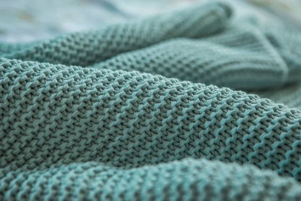 Rahat bir ekoseye basit desenler ördüm, arka planda bulanık mavi örgü dokular, örgü örme, yaratıcılık, dikiş, örgü örme, kumaş katları, yakın plan, alan derinliği, bulanıklığı, perspektif