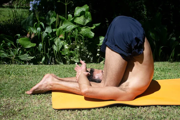 yoga outdoor in a relax position, young and flexibility man