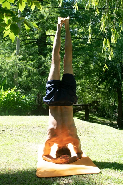 yoga outdoor in a relax position, young and flexibility man, with orange yoga mat