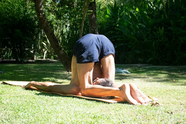 An adult man doing yoga outdoor in a relax position