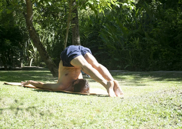 An adult man doing yoga outdoor in a relax position