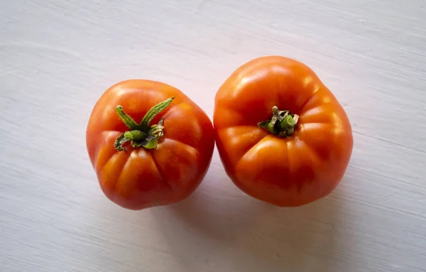 Two organics tomatoes on a white background with top view
