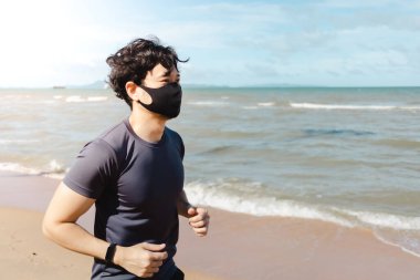 Adam yaz sabahı plajda maskeyle koşuyor..