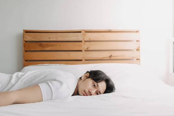 Exhausted man lay on the bed as he feels burnout. — Stock Photo, Image