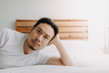 Yorgun bir adam yorgun hissederken yatağa uzandı..