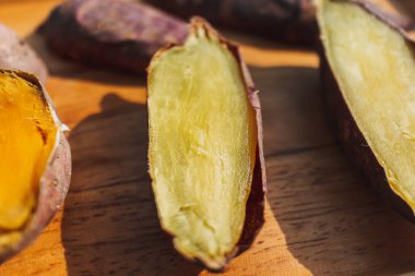 Tahta tabakta ikiye bölünmüş tatlı patates.