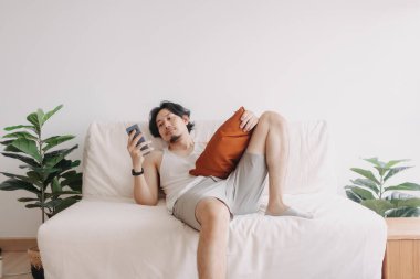 Sıkılmış adam rahatlamış ve akıllı telefonu evde yalnız zaman geçirmek için kullanmış..