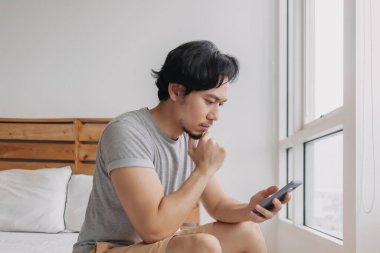 Akıllı telefonlara ciddi ciddi bakan bir adam..